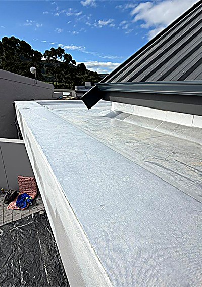 Flat concrete roof deck finished with a white waterproofing membrane